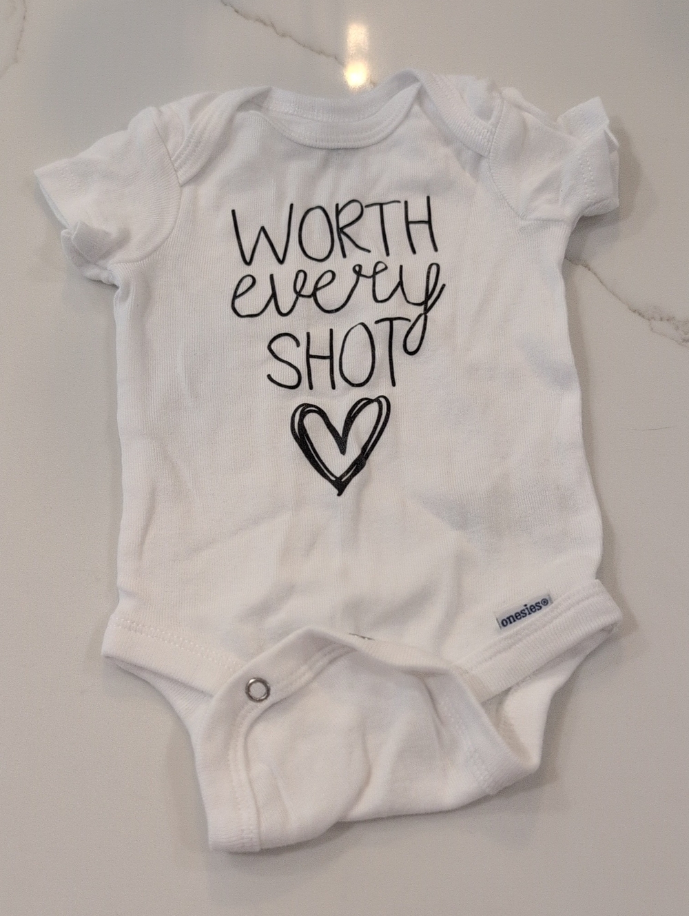 Gerber White Baby Onesie with 'Worth Every Shot' Heart Graphic